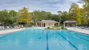 una gran piscina con sillas y cenador en Sandpiper Village 715 en Destin