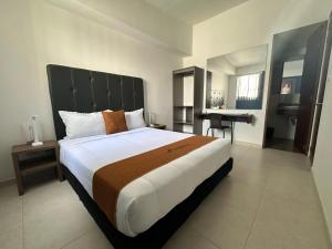 Habitación grande con cama grande y escritorio. en PERUGINO´S HOTEL GALERIA en Popayán