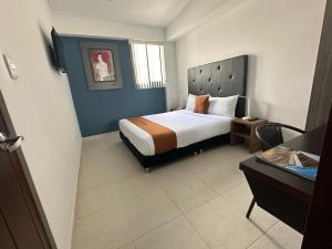 Habitación de hotel con cama y escritorio en PERUGINO´S HOTEL GALERIA, en Popayán