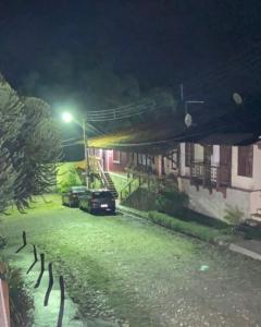 un grupo de coches estacionados frente a un edificio por la noche en Casa Aconchego Guaramiranga, en Guaramiranga