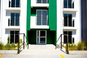 un edificio con una fachada verde y blanca en Apartamento e109, en Guatemala