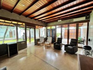 a living room with chairs and tables and windows at Sanctuary Ceylon by Ceylon Spaces in Ratmalana South