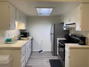 a kitchen with white cabinets and a black refrigerator at Central Bellevue Guesthouse in Bellevue