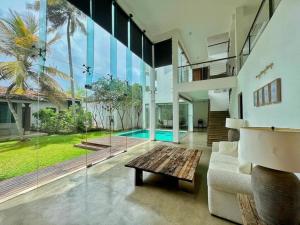 a living room with a couch and a table at Sanctuary Ceylon by Ceylon Spaces in Ratmalana South