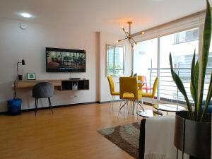 a living room with a table and yellow chairs at Downtown Quito - Balcony - Gym - Parking - 7thFLOOR in Quito