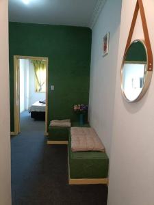 une salle verte avec un banc et un miroir dans l'établissement Studio Niterói-Barcas 604, à Niterói