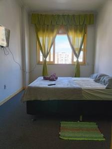 a bedroom with a large bed with a window at Studio Niterói-Barcas 604 in Niterói