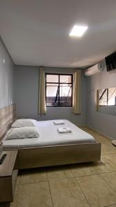 a large bed in a room with a window at Hotel city Clélia in Sao Paulo +57 photos