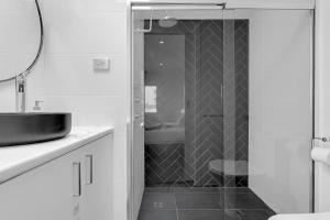 a bathroom with a shower with a sink and a mirror at 2BR Townhouse CBD Chinatown Free WiFi FreeParking in Adelaide +32 photos