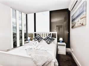 sypialnia z białym łóżkiem i dużym oknem w obiekcie Iconic on Vue with Free Parking Pool Gym CBD w mieście Adelaide