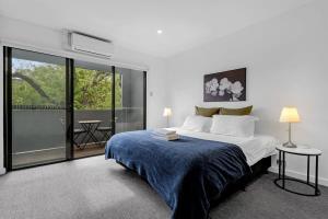 a bedroom with a large bed with a blue blanket at 2BR Townhouse CBD Chinatown Free WiFi FreeParking in Adelaide