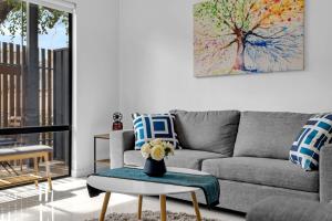 un salon avec un canapé et une table dans l'établissement 2BR Townhouse CBD Chinatown Free WiFi FreeParking, à Adélaïde