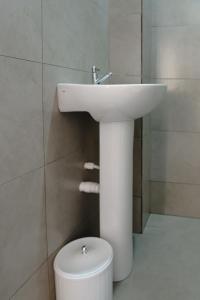 a bathroom with a white sink and a toilet at Hotel city Clélia in São Paulo