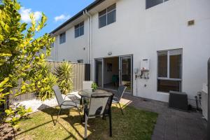 a patio with a table and chairs in front of a building at The Charming Living 3BR Townhouse Perfect Vacation in Birkenhead