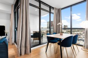 a dining room with a table and chairs and a large window at The elegant 1BR CBD Apt - City view - Parking in Adelaide