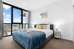 a bedroom with a large bed and a large window at The elegant 1BR CBD Apt - City view - Parking in Adelaide