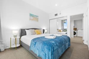 a bedroom with a large bed with a blue blanket at The elegant 1BR CBD Apt - City view - Parking in Adelaide