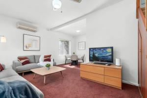 a living room with a couch and a tv at In Between City Sea & Airport - 2BR Vacation Home in Plympton