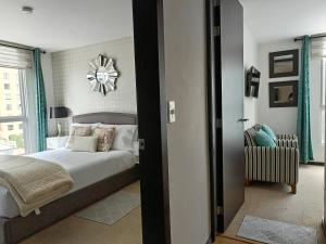 1 dormitorio con 1 cama y reloj en la pared en Downtown Quito - Balcony - Gym - Parking - 7thFLOOR, en Quito