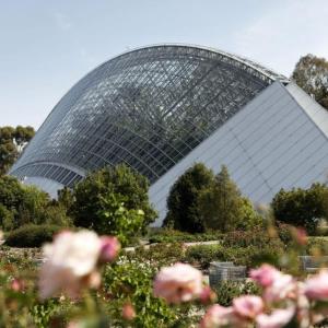 een glazen huis in een tuin met roze bloemen bij The CBD Hidden Gem 1BR Central & Walkable Haven in Adelaide