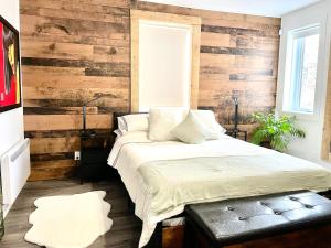 1 dormitorio con 1 cama y pared de madera en Svetlana et Dominick en Joliette