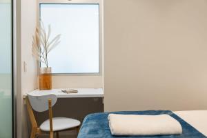 a bedroom with a bed and a desk and a chair at 2BR CBD Apt Swimming Pool Sauna SPA CBD in Adelaide