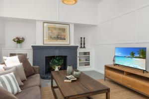 un soggiorno con un divano e una TV di Captains Cottage - Huskisson a Huskisson