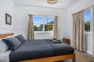 una camera da letto con un letto e due finestre di Captains Cottage - Huskisson a Huskisson