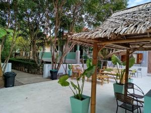 a patio with a wooden pergola and chairs at Luana Villas in Ban Mo Nae