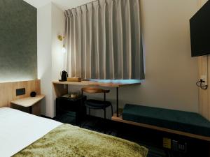 a hotel room with a bed and a window at R Hotel Kansai Airport in Izumi-Sano