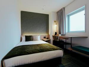 a hotel room with a bed and a window at R Hotel Kansai Airport in Izumi-Sano