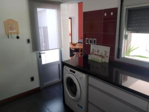 een keuken met een wasmachine bij Linda y cómoda casa en Colonia del Sacramento in Colonia del Sacramento