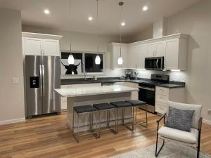 a kitchen with white cabinets and a kitchen island with bar stools at Bright Napa Home in Napa