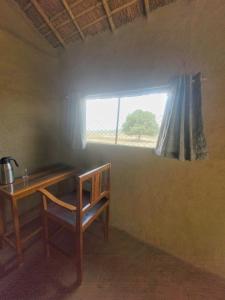 um pequeno quarto com uma mesa e uma janela em Ishq Sanctum- A Conscious Guest House em Bhagaura