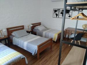 a room with three beds and a ladder at Linda y cómoda casa en Colonia del Sacramento in Colonia del Sacramento