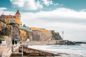 budynek na szczycie klifu nad oceanem w obiekcie Casa de praia w mieście Estoril