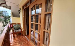 um quarto com uma porta de madeira e uma varanda em Hospedaje "LOS QUETZALES DE OXAPAMPA" em Oxapampa