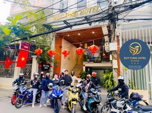 un grupo de personas en motocicleta frente a un edificio en Duy Tung Hotel Da Nang en Da Nang