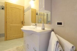 ein weißes Badezimmer mit einem Waschbecken und einem Spiegel in der Unterkunft Bella Vista in Canale San Bovo