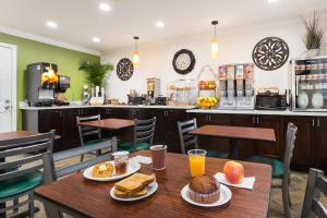 a dining room with a table with breakfast foods at Rodeway Inn San Jose HWY-101 Tully Rd Exit in San Jose