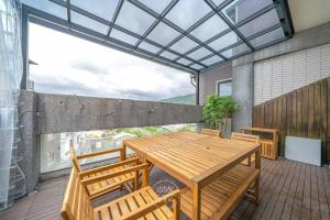 patio con mesa de madera y sillas en el balcón en 田園走走 en Jiaoxi