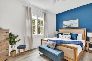 1 dormitorio con paredes azules, 1 cama y 1 silla azul en Da Beach House, en Destin
