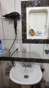 a bathroom with a sink and a hair dryer on the wall at Departamento en el centro Histórico CDMX. in Mexico City