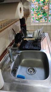 a kitchen sink with dishes on a drying rack at Departamento en el centro Histórico CDMX Bolivar 8 Edificio SANTA CLARA in Mexico City