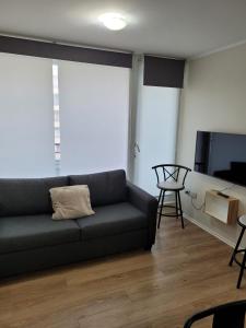 a living room with a couch and a flat screen tv at Departamento Brisa del sol in Talcahuano