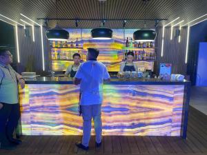 a group of people standing at a colorful bar at Acro Residences in Guiguinto