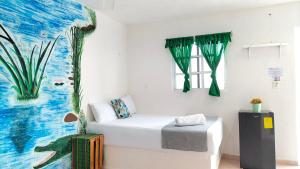 a room with a bed and a painting on the wall at HOTEL LAS COLORADAS in Yuluc