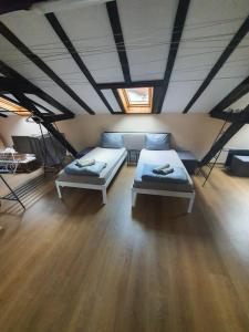 two beds in a room with wood floors and ceilings at Kapana Stay at Center Plovdiv in Plovdiv