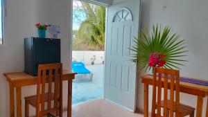 a dining room with a table and chairs and a door at HOTEL LAS COLORADAS in Yuluc