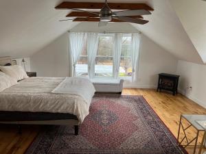 Country House in Catskills في ساوغيرتيس: غرفة نوم بسرير ومروحة سقف